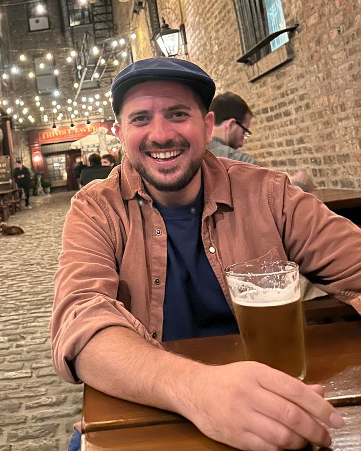 Goga, co-founder of B.B. Custom, smiling at an outdoor table